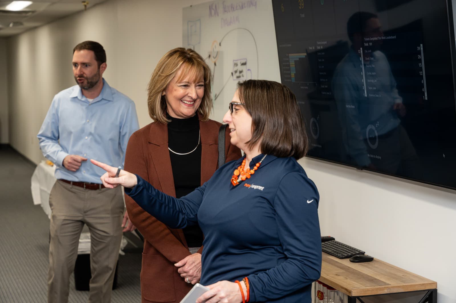 An NSN Management team member walking visitors through the board at the Tulsa office